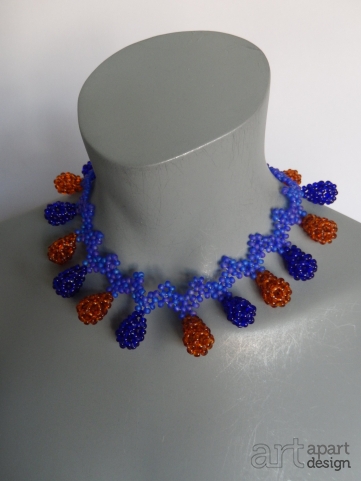 040 halssieraad kort paarse zigzag met blauwe en honigkleurige druppels